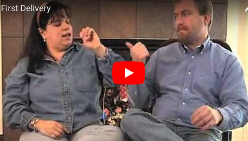 A man and woman in denim sit and talk in sign