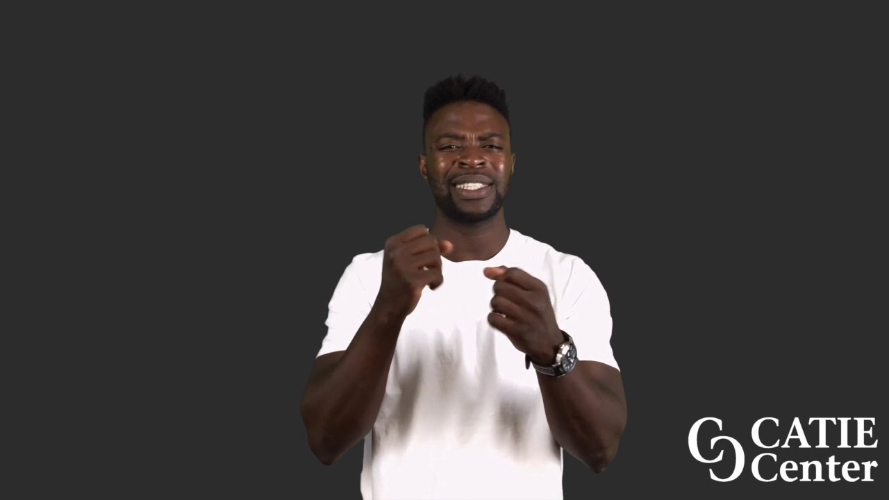 A Black man with a flattop wears a white short-sleeve t-shirt and stands in front of a dark grey background. He narrates the entire story.  In the lower right corner of the video screen is a white CATIE Center logo