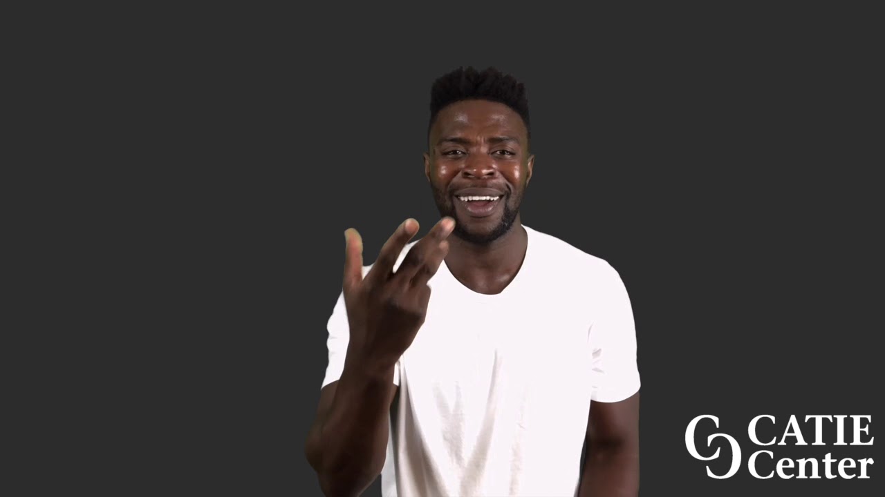A Black man with a flattop haircut wears a white short-sleeve t-shirt and stands in front of a dark grey background. He narrates the entire story.  In the lower right corner of the video screen is a white CATIE Center logo.
