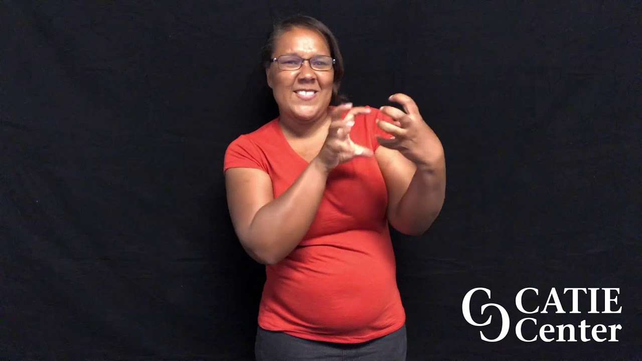 Light skinned woman wearing orange short-sleeve shirt is shown from the waist up. She is standing in front of a dark-grey screen. A white CATIE Center logo is in the lower right corner of the screen. The woman narrates the entire video in American Sign Language.