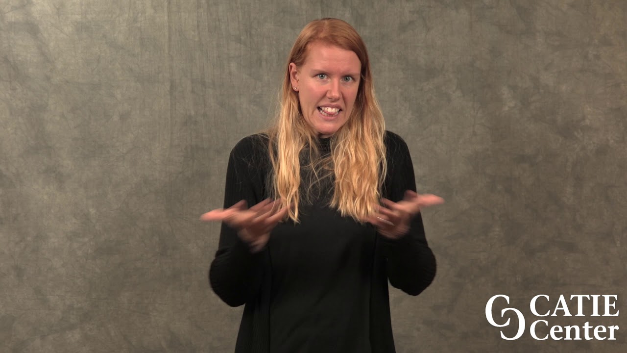 Jenny Smith, a tall white woman with long red hair wearing a black long sleeve shirt, stands in front of a grey background.  The CATIE Center logo is in the right lower hand corner of the video.