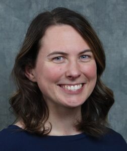 Headshot of a smiling white woman with shoulder length brown hair